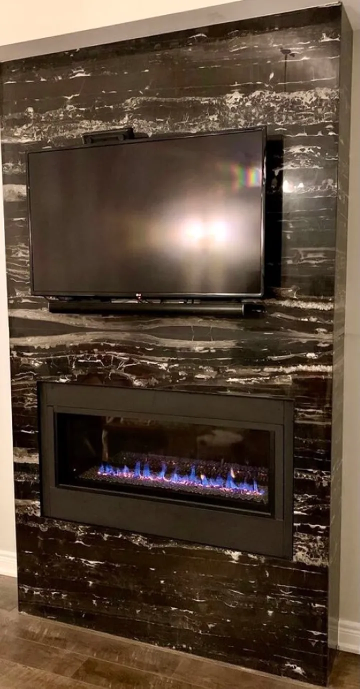 Dark porcelain slab fireplace wall with a linear firebox