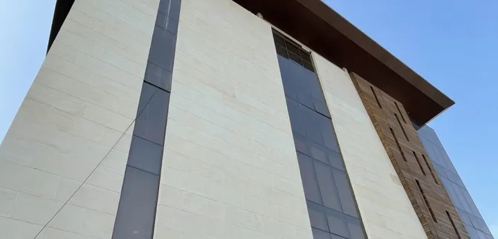 Commercial facade with stone-look panels, glass, and wood-look cladding